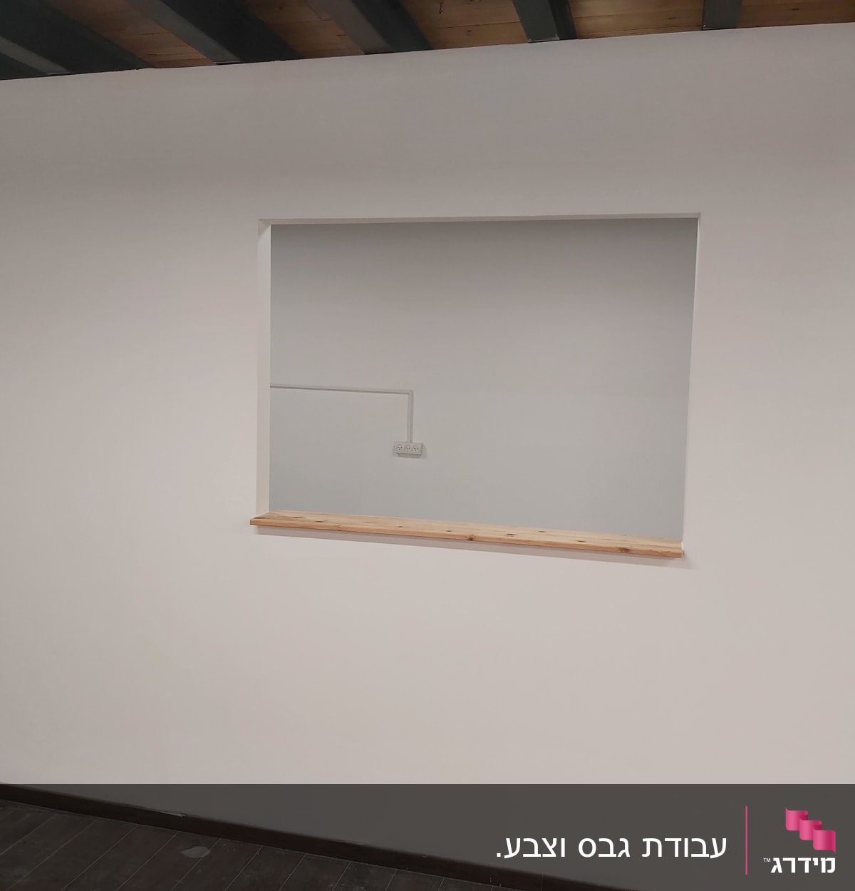 קיר גבס עם חלון פנימי ומדף עץ